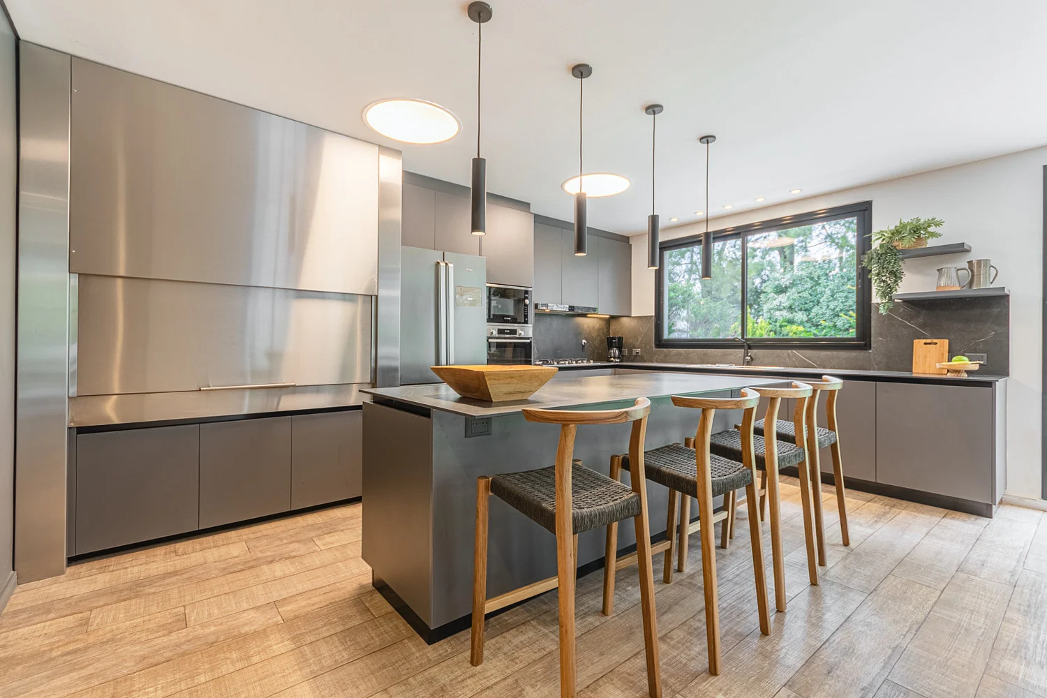 Cocina gris con isla y banquetas de madera