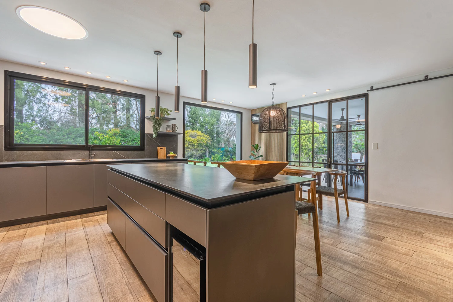 Cocina moderna gris con isla central y mesada oscura