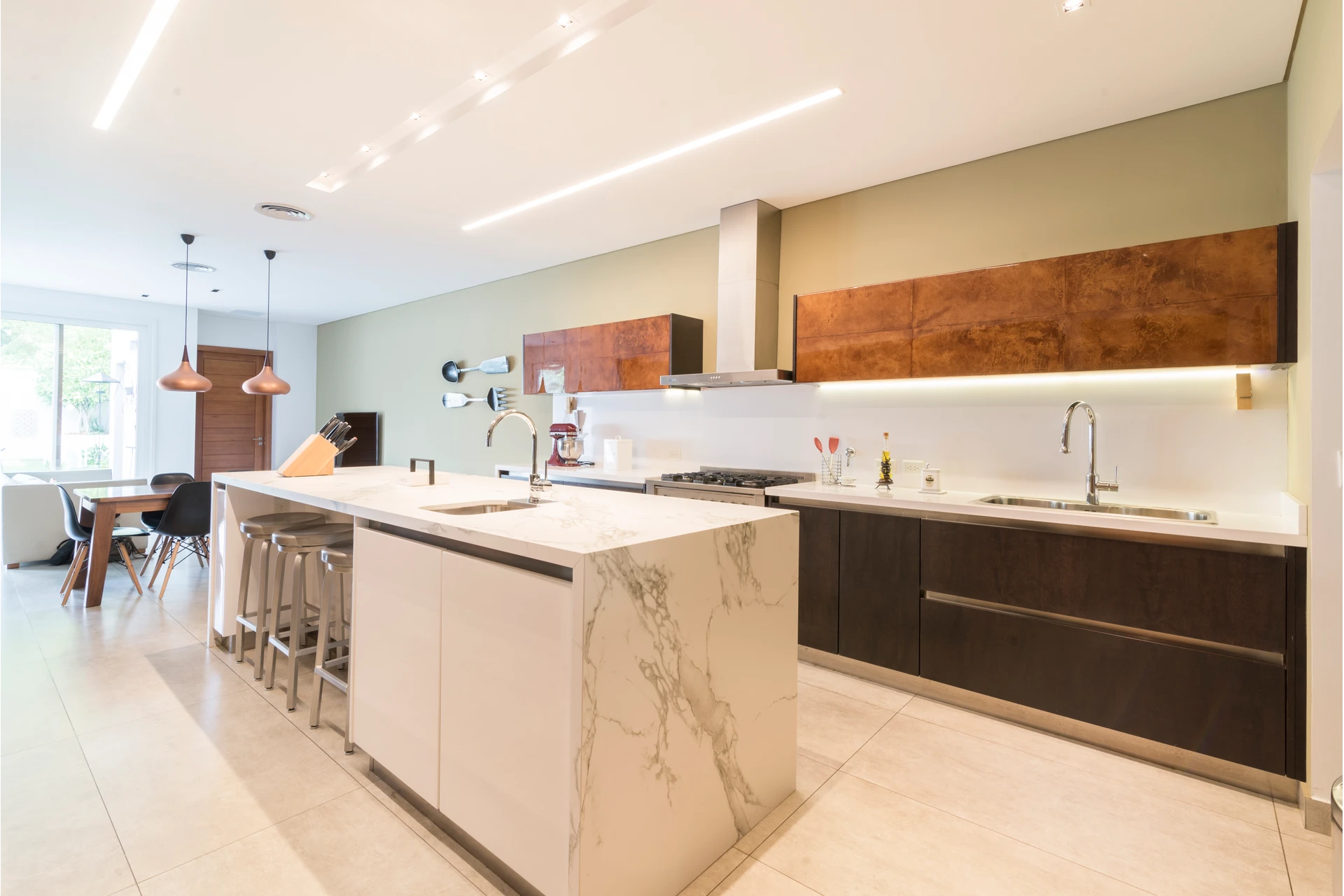 Cocina a medida con isla blanca y alacenas de madera