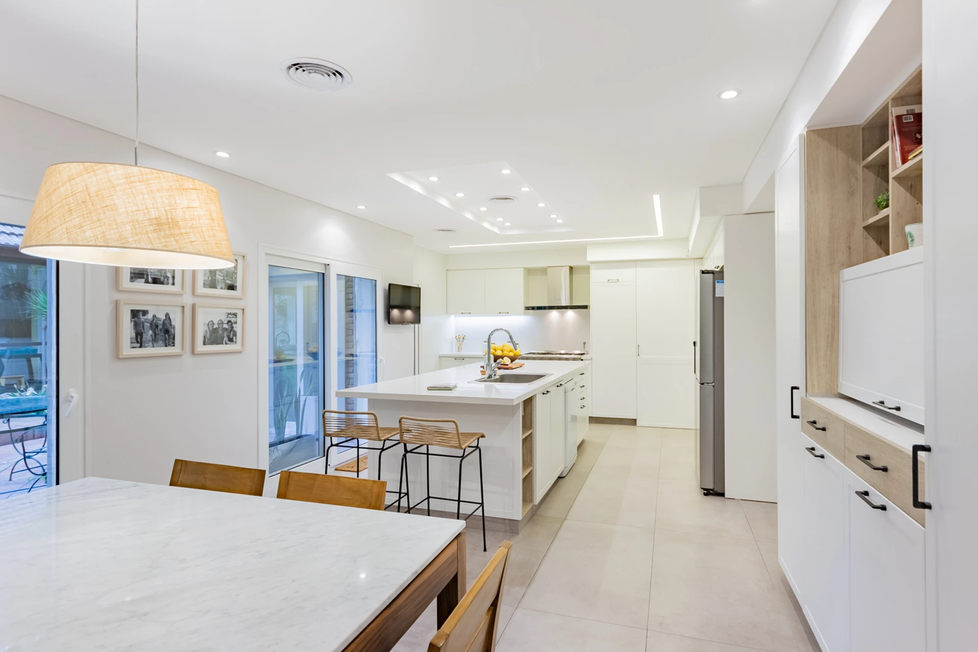 Cocina blanca integrada al comedor con isla