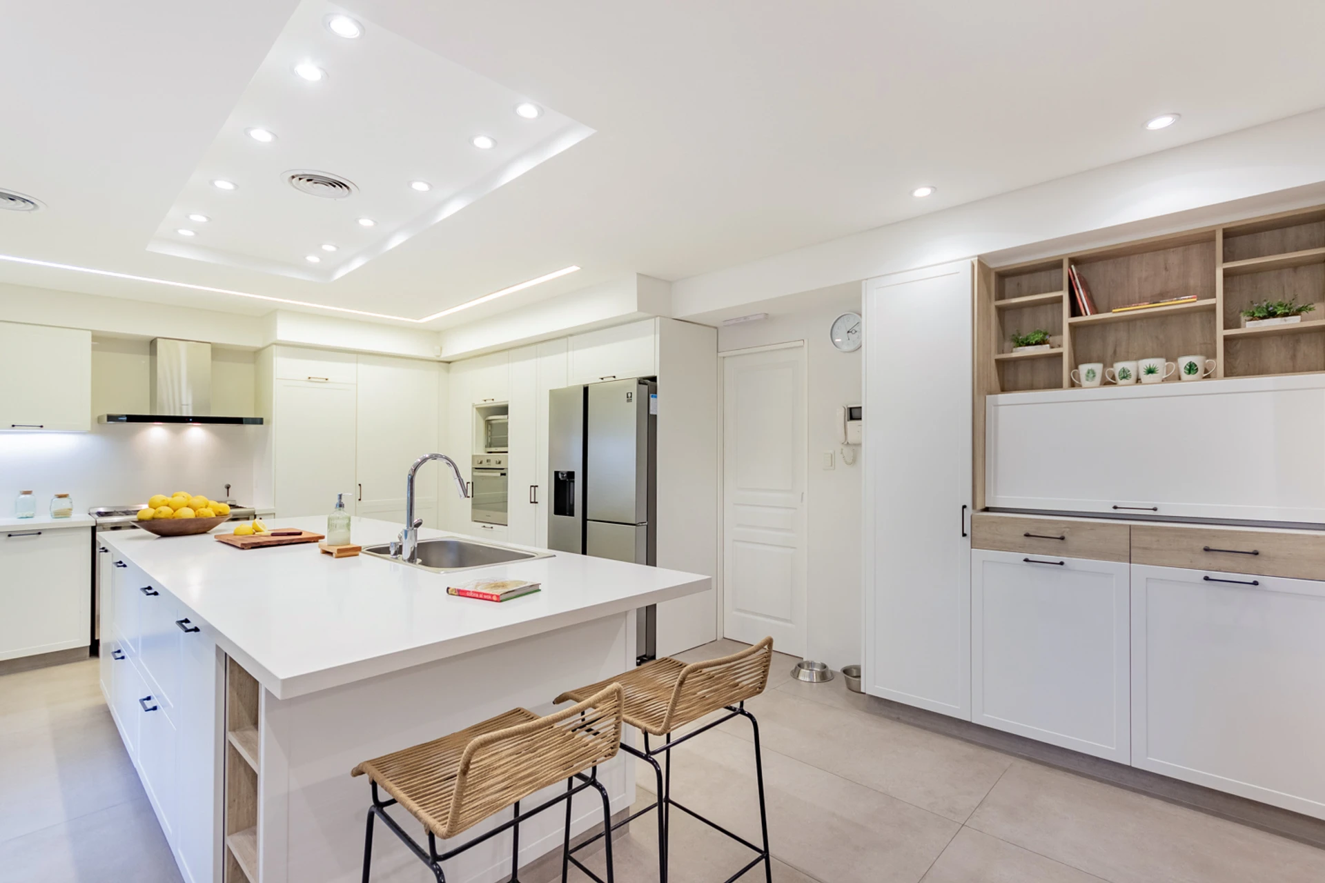 Cocina blanca con isla y banquetas