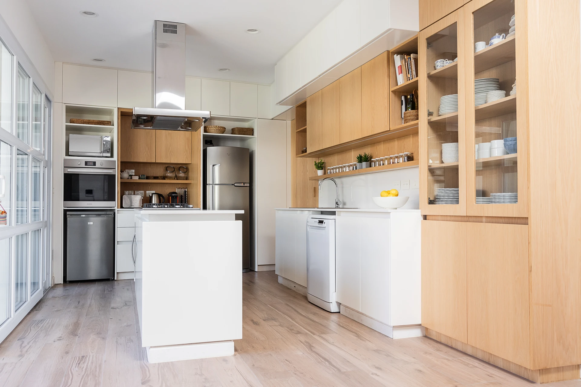 Cocina blanca con alacenas de madera y estantes abiertos