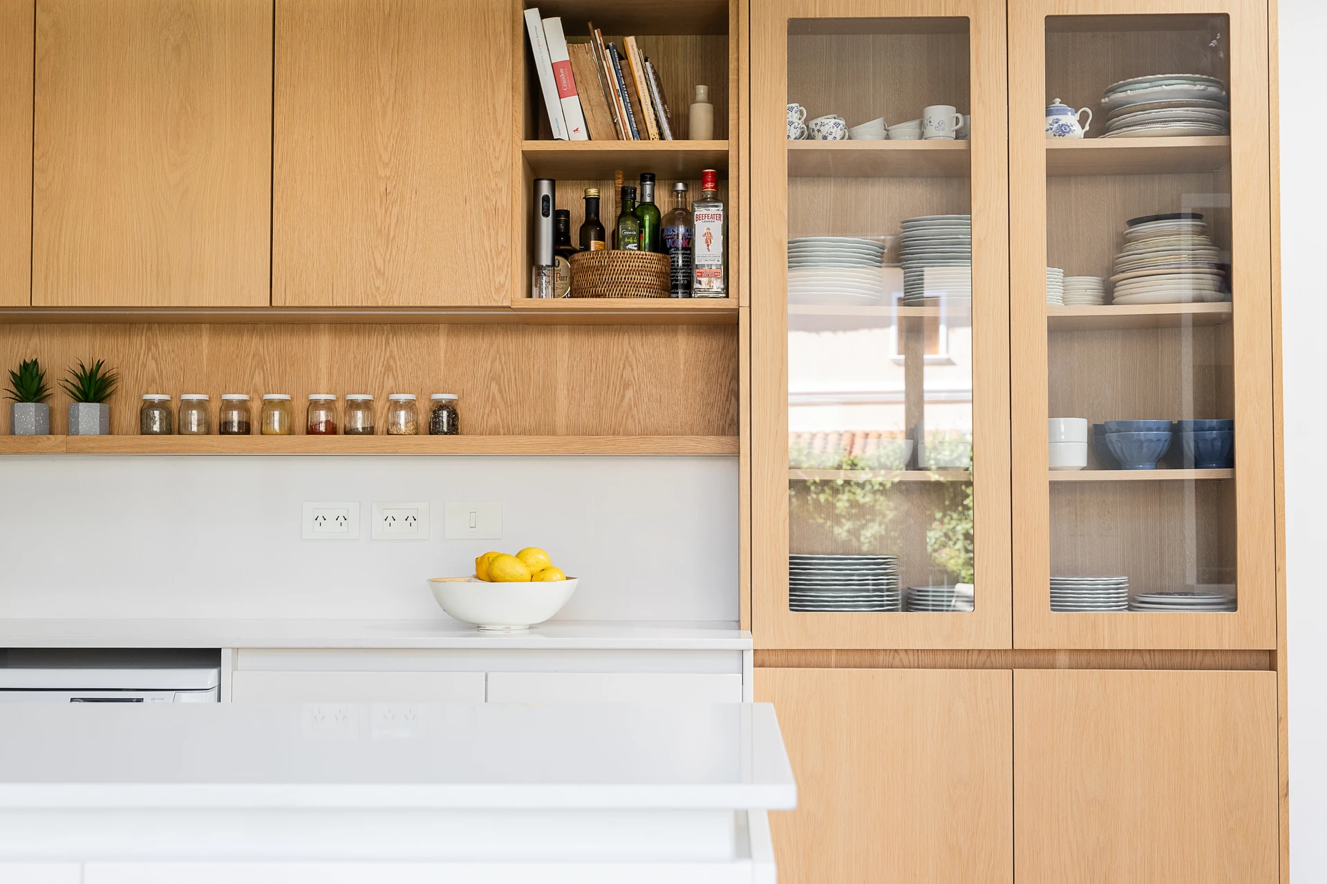 Alacenas de madera y estantes abiertos en cocina blanca