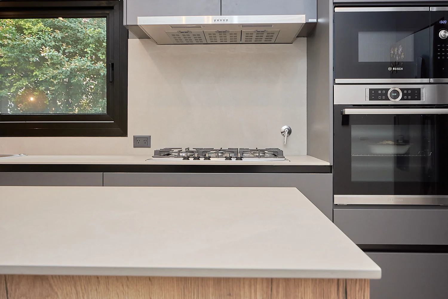Mesada de cocina blanca con anafe y horno empotrado