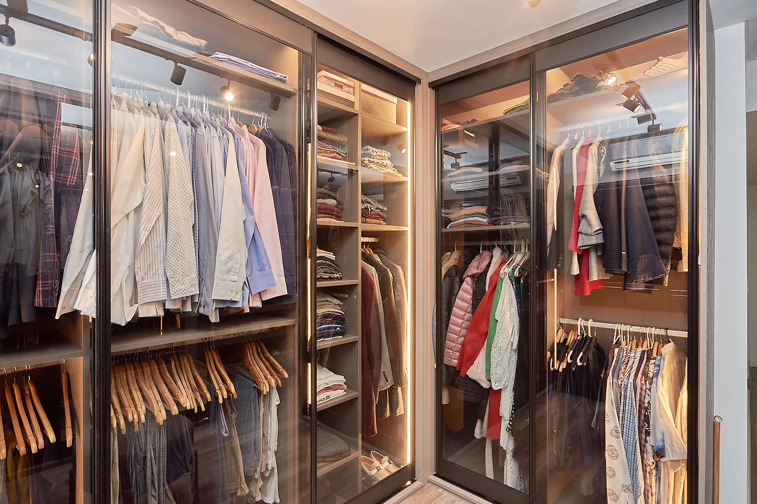 Vestidor con estantes de madera y ropa colgada